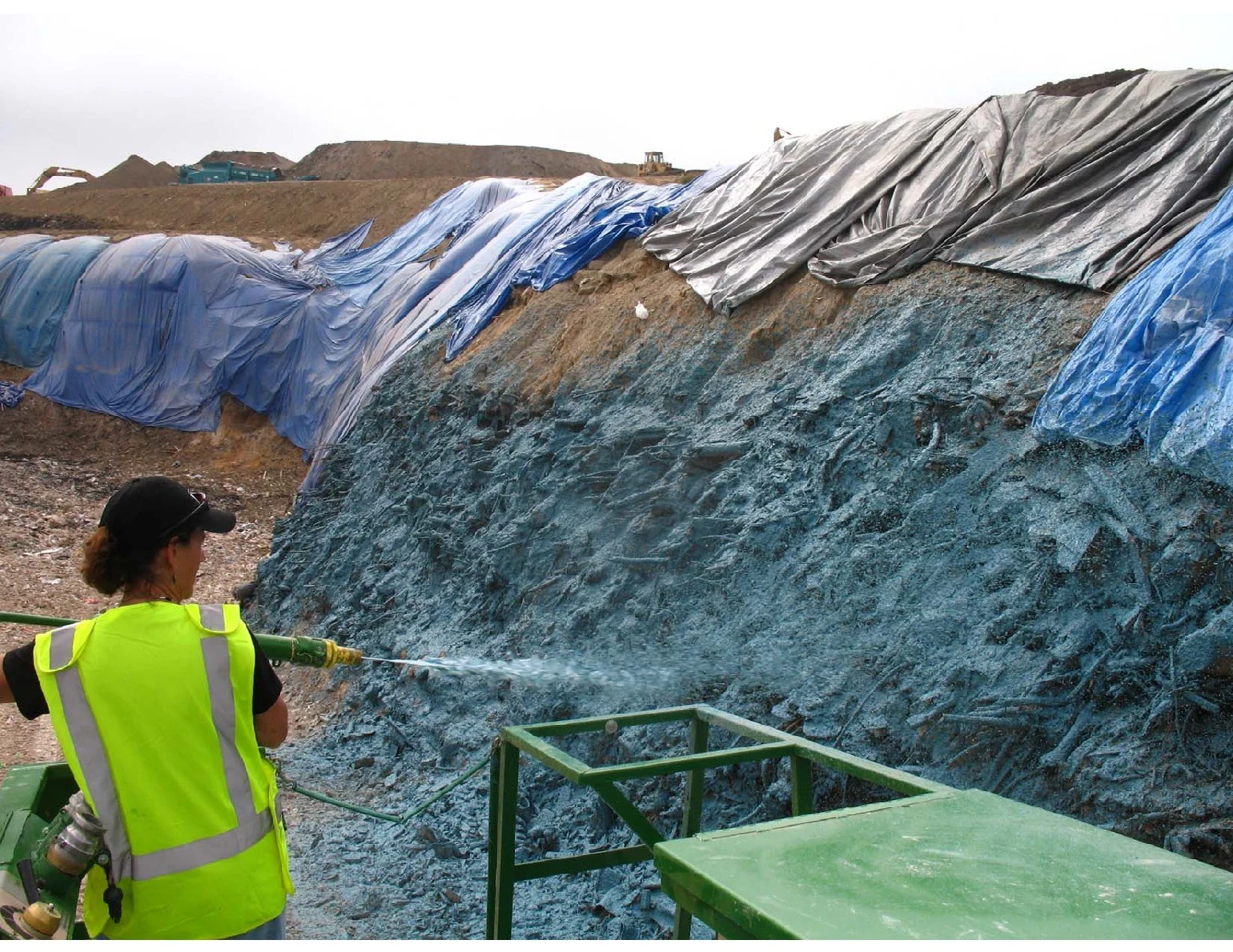 Spray-applied cover on a vertical excavation wall at Potomac Landfill, with tarps visible above